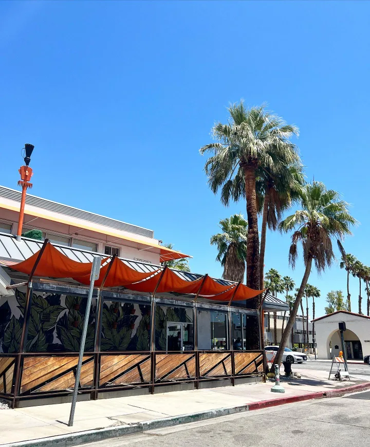 Ernest Coffee's colorful Palm Springs exterior with orange awnings and palm trees